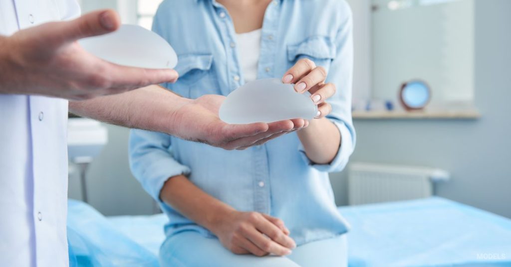 woman and her doctor (models) discussing implants at a breast augmentation consultation.